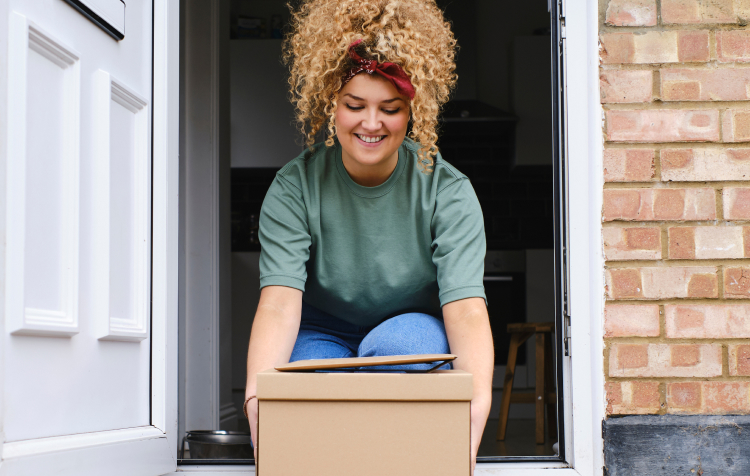 Woman picking up package on front porch