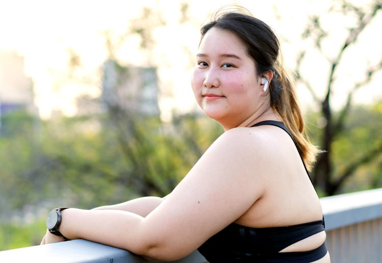 Woman smiling and wearing earbuds