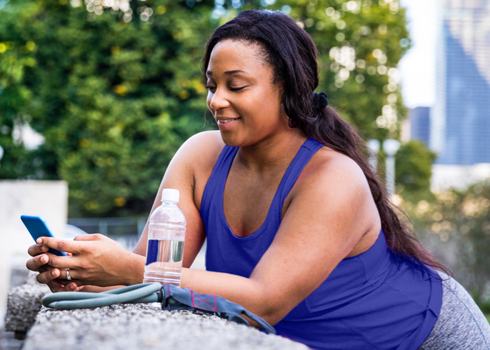 Woman standing outside and texting on a cell phone