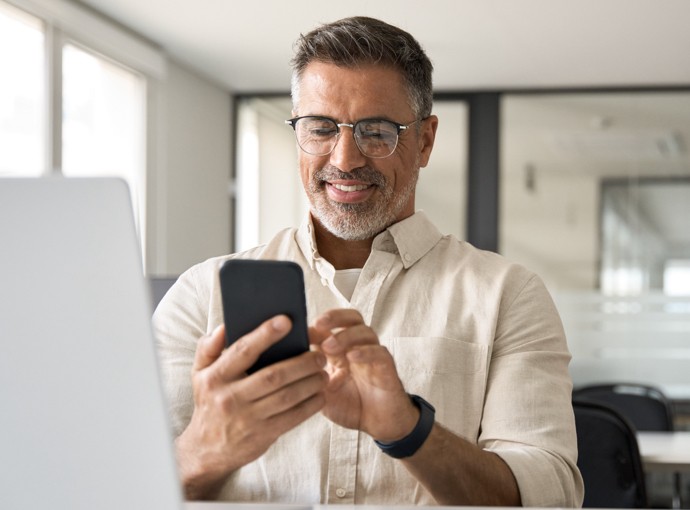 Man with glasses looking at phone