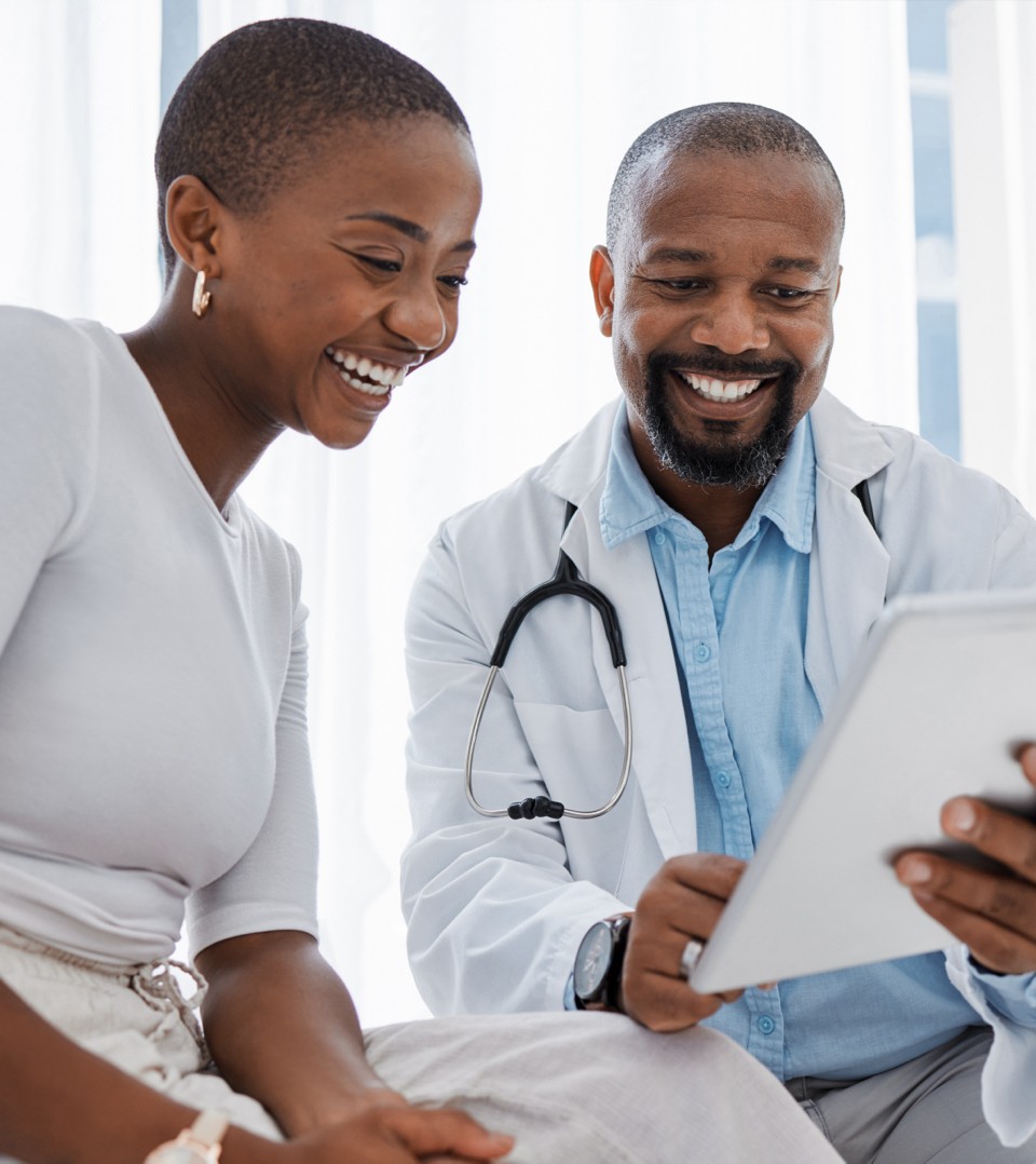 Patient and doctor smiling looking at a tablet