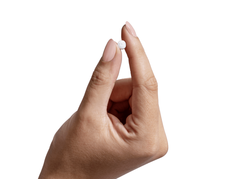 Hand holding a medication pill